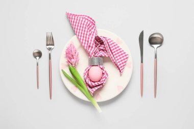 Paskalya sofrasında boyalı yumurta, sümbül çiçeği ve gri arka planda peçete.