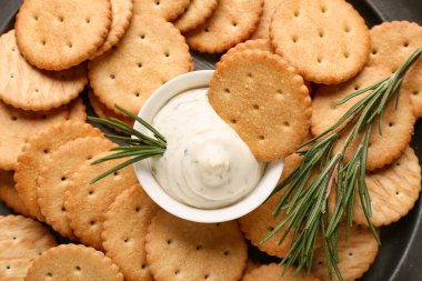 Lezzetli krakerler, bir kase sos ve biberiye, yakın plan.