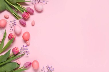 Güzel çiçeklerle boyanmış Paskalya yumurtaları ve pembe arka planda tüy.