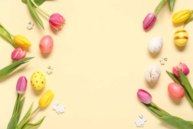 Paskalya yumurtalarından yapılmış, güzel lale çiçekleri ve bej arka planda dekoratif tavşanlardan yapılmış.