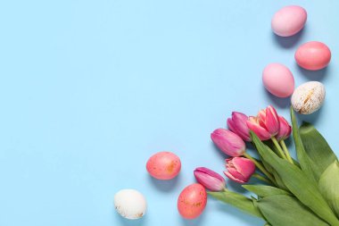 Mavi arka planda lale çiçekleriyle boyanmış Paskalya yumurtaları.