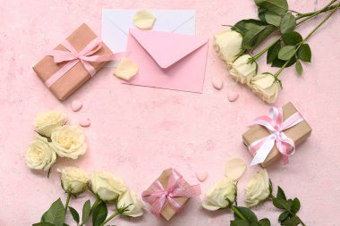 Hediye kutularından, beyaz gül çiçeklerinden ve pembe grunge arkaplanındaki zarflardan yapılmış çerçeve