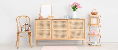 Sandalyesi, ahşap dolabı ve Paskalya süslemeleri olan ışık odasının içi.