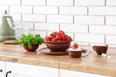 Mutfakta lezzetli çilek, şeker ve naneli kase.