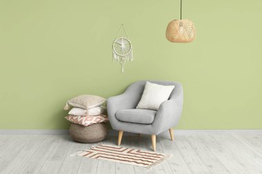 Koltuk ve yastıklar yeşil duvarın yanındaki pouf üzerinde.