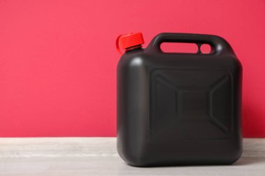 Kırmızı duvarın yanındaki siyah plastik kutu.