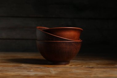 Ahşap arka planda kahverengi kaseler yığını