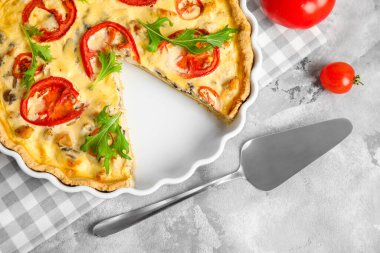 Gri arka planda roka yapraklı lezzetli domates tartı, yakın plan.