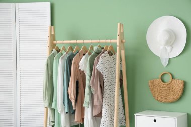 Giysi askısı, katlama perdesi ve raf ünitesi olan şık bir soyunma odası.