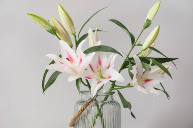 Gri duvarın yanında güzel çiçekli vazo, yakın plan.