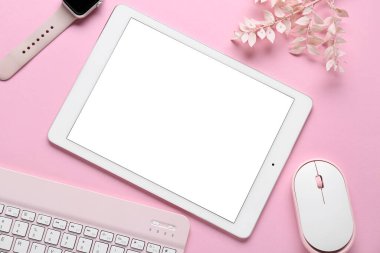 Modern tablet bilgisayarlı kompozisyon, akıllı saat, PC fare, klavye ve pembe arkaplanda dekoratif çiçekler, yakın plan