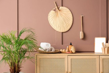 Temiz havlular, ayna, masaj vücut fırçaları ve banyonun içindeki kozmetik ürünlerin olduğu çekmeceler, yakın plan.