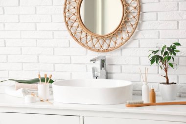 Lavabo, diş fırçası ve çekmecelerde tuvalet malzemesi olan hafif bir banyo.