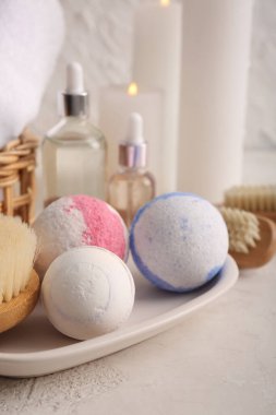 Tepsi ve farklı banyo bombalarıyla bej renginde kompozisyon, yakın plan.