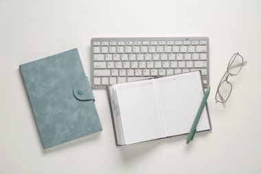 Beyaz arkaplanda dizüstü bilgisayarlı klavye ve gözlüklü kompozisyon