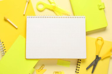 Sarı arkaplanda boş defter ve okul sayfası olan kompozisyon, kapat
