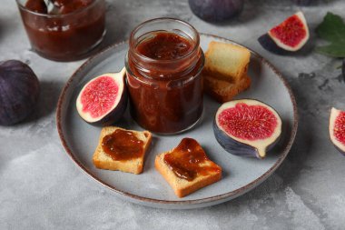 Gri grunge arka planda tatlı incir reçeli tabağı ve lezzetli tostlar.