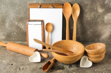 Ahşap pişirme aletleri ve gri grunge arka planda boş kağıt çarşaflar