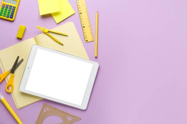 Leylak arka planında okul kırtasiyesi ve tablet bilgisayarı olan kompozisyon