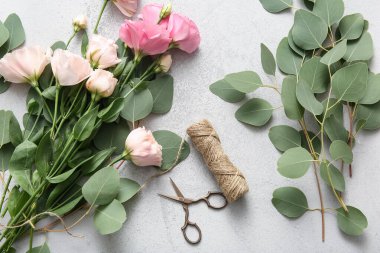 Gri grunge arka planında güzel pembe Eustoma çiçekleri, makas ve iplikleri olan kompozisyon
