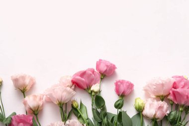 Açık pembe arka planda güzel Eustoma çiçekleri olan kompozisyon