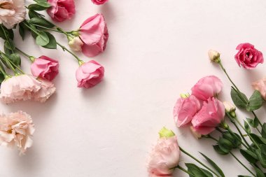 Açık pembe arka planda güzel Eustoma çiçeklerinden yapılmış çerçeve, yakın plan