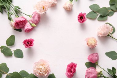 Güzel pembe Eustoma çiçeklerinden yapılmış çerçeve ve açık pembe arka planda yapraklar