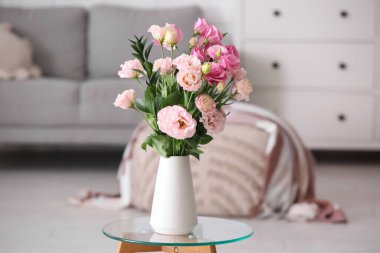 Oturma odasının iç tarafındaki masada güzel Eustoma çiçekleri olan vazo.