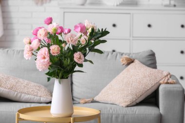 Oturma odasının iç tarafındaki masada güzel Eustoma çiçekleri olan vazo.