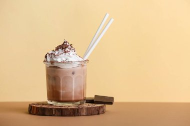 Bir bardak krem şantili ve çikolatalı soğuk kakao. Sarı arka planda.