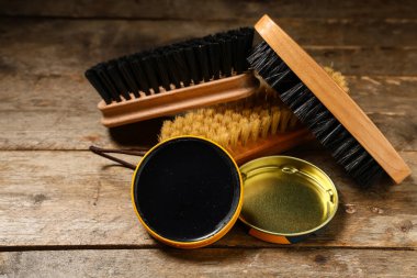 Ahşap arka planda fırçalı ayakkabı boyası, yakın plan.