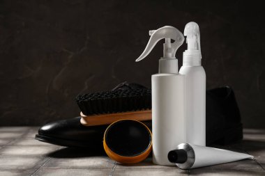 Siyah arka planda gri fayans üzerinde fırça ve ayakkabı boyaları