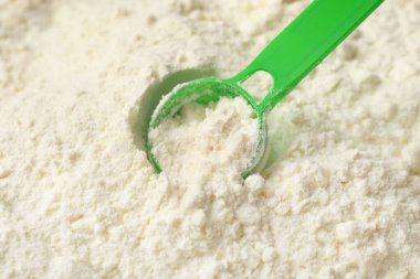 Toz bebek sütü formülünün dokusu, arka plan olarak kepçeyle, yakın plan