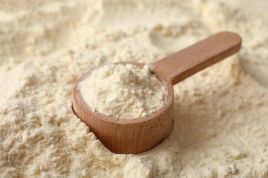 Arka plan olarak ahşap kepçe ile toz bebek sütü formülü dokusu, yakın plan