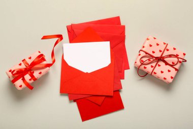 İçinde zarflar ve gri arka planda hediye kutuları olan boş bir kart. Sevgililer Günü kutlaması