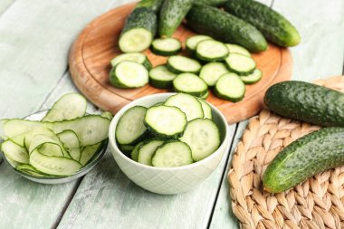 Hafif ahşap arka planda taze kesilmiş salatalıklı kaseler.