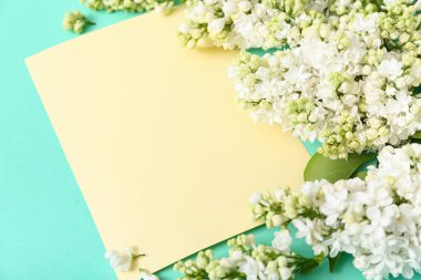 Sarı boş kart ve turkuaz arka planda leylak çiçekleri