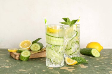 Yeşil masada salatalıklı limonata ve nane şekeri.