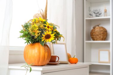 Sonbahar çiçekli balkabakları, kahve fincanı ve çerçeve oturma odasında klozetin üzerinde.