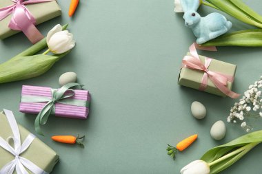 Çiçekli Paskalya yumurtaları, hediye kutuları ve yeşil arka planda tavşan.