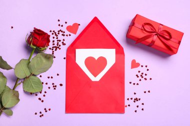 Kağıt kalpli zarf, hediye kutusu ve leylak arkaplanlı güzel kırmızı gül. Sevgililer Günü kutlaması