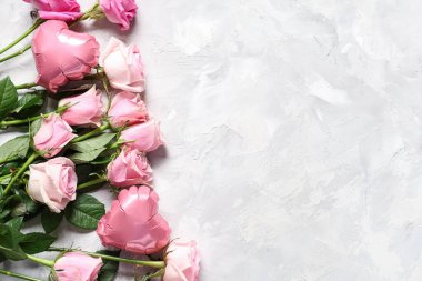 Beyaz grunge arka planında gül çiçekleri ve kalp şeklinde balonlar olan kompozisyon. Sevgililer Günü kutlaması