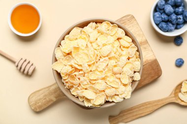 Bej arka planda lezzetli mısır gevreği, yabanmersini ve bal içeren kompozisyon, yakın plan.