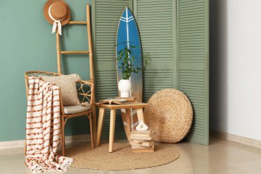 Oturma odası, koltuk, sehpa ve sörf tahtası.