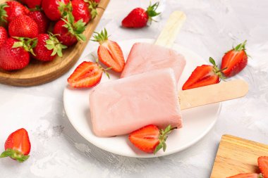 Tatlı çilekli dondurma tabağı ve gri arka planda böğürtlen tabağı.