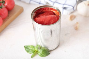 Açık arkaplanda domatesli teneke kutu