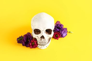 Sarı arka planda güzel çiçekli insan kafatası