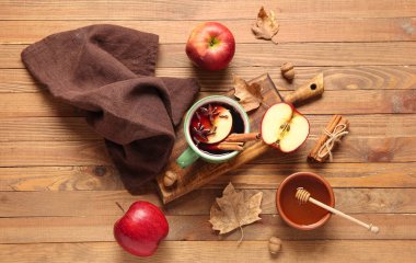 Elmalı sıcak şarap ve ahşap arka planda bal.