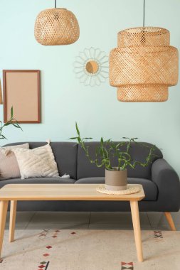 Rahat siyah kanepesi ve bambu bitkisi olan modern oturma odası.