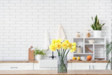 Mutfaktaki cam vazoda bir buket nergis.